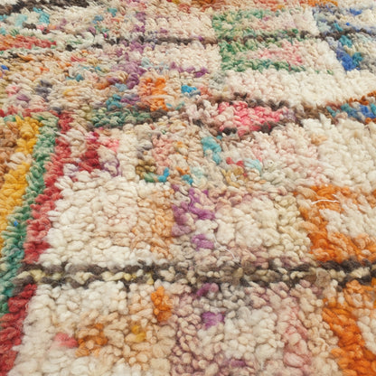 Close-up of a Yaftna Moroccan rug showing the soft wool pile with the dense multicolor confetti pattern - flecks of turquoise, orange, pink and blue scattered across the ivory ground, handwoven in 100% wool