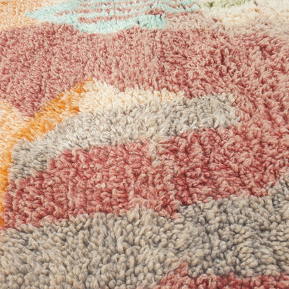 Close-up of a Makyna Moroccan rug showing the soft wool pile with the muted pastel patchwork pattern - dusty mauve and sage colour blocks meeting softly against the ivory ground, handwoven in 100% wool
