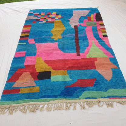 Authentic Boujad Moroccan rug 257×360 cm laid flat — electric cobalt blue background with large bold abstract geometric shapes in hot pink, red, mustard yellow, lime green, lavender, salmon and black, handmade in Morocco by Berber women, a unique piece of floor art