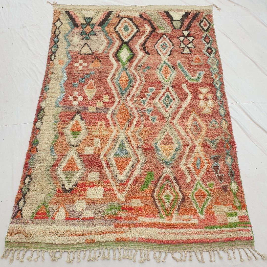 Authentic Moroccan rug 194x304 cm laid flat outdoors - warm terracotta and rust ground with a classic cream diamond lattice pattern in orange, green and teal, handwoven in Morocco