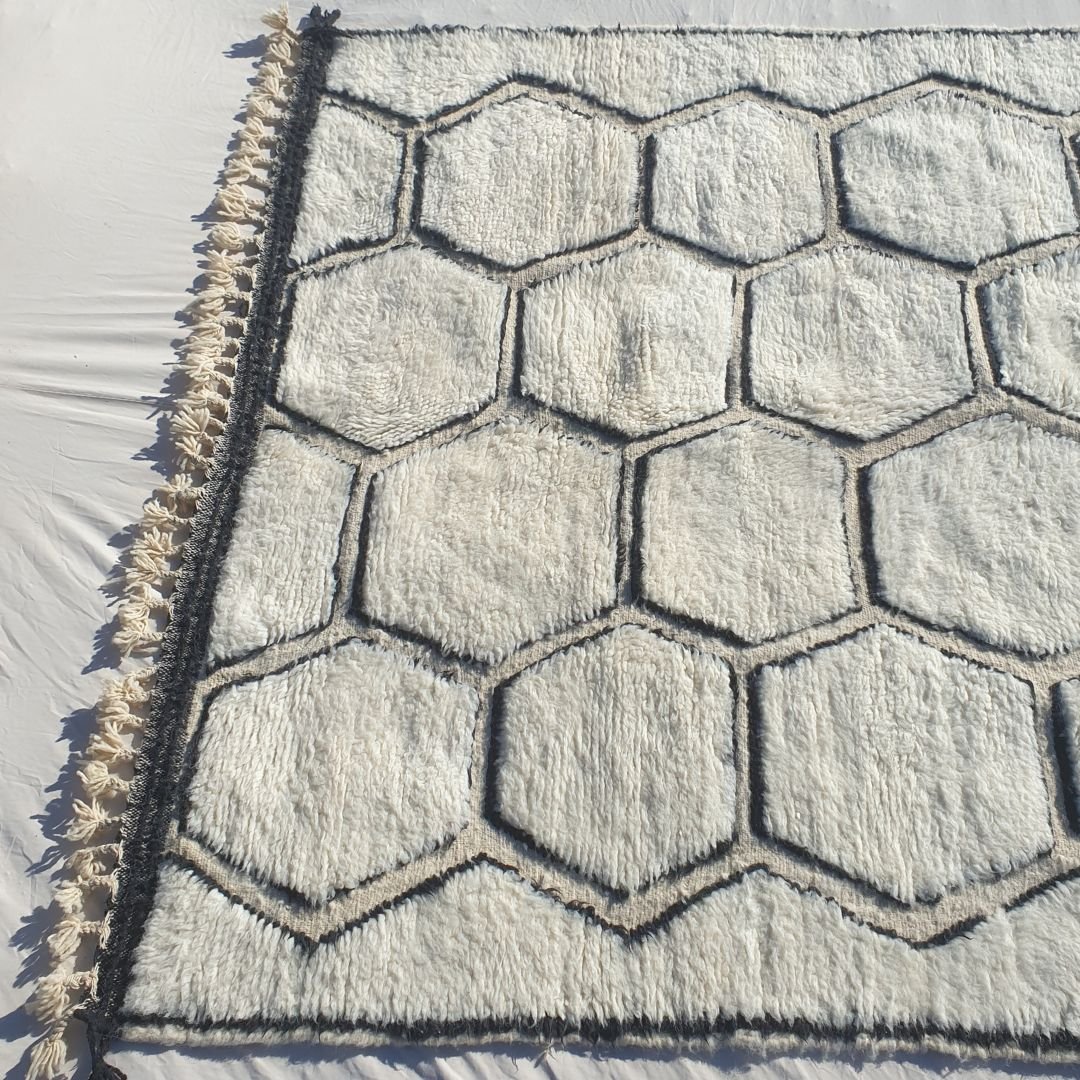 Thick, plush high-pile wool of black and white honeycomb Beni Ourain Berber shag rug with soft natural ivory background and deep black contrasts