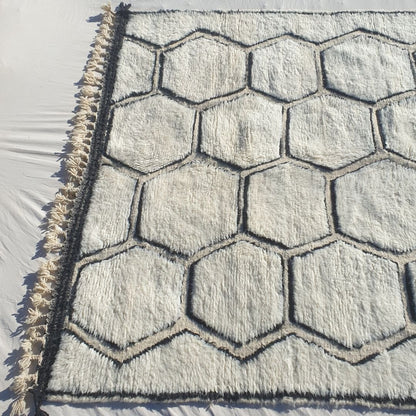 Thick, plush high-pile wool of black and white honeycomb Beni Ourain Berber shag rug with soft natural ivory background and deep black contrasts