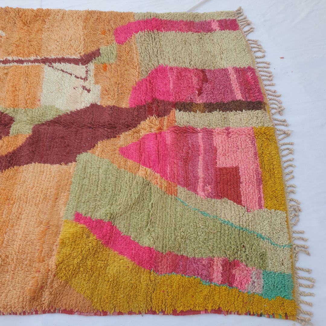 Lower half of Claha Moroccan Berber rug with bold hot pink and blush-pink layered stripes, olive green sections, golden yellow and teal accents on cream base in dense fluffy handwoven wool.