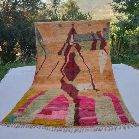 large peach-orange Boujad Moroccan rug in nature, showing a dramatic large burgundy abstract figure in the centre with hot pink, olive and golden yellow below.