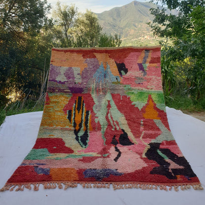 large red Boujad Moroccan rug in nature, bold painterly abstract shapes in teal, black, lime green, purple and orange on coral-red ground.