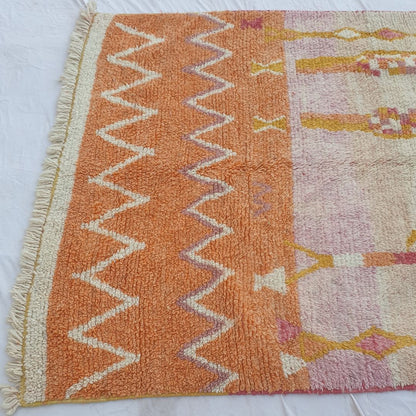 Plush wool pile and natural color gradients in vibrant orange, pink and beige of vintage-style Boujad Berber rug with symbolic tribal art