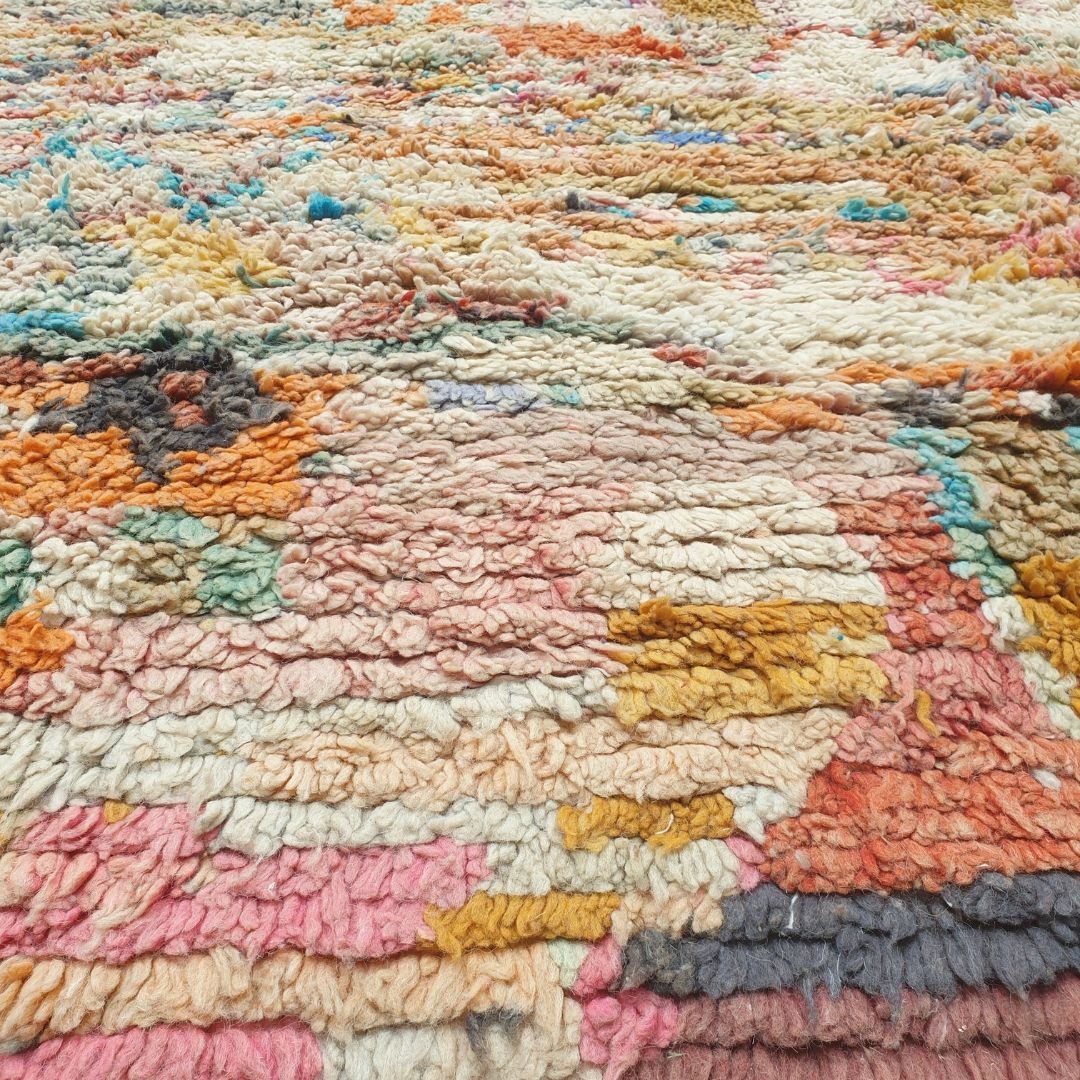 Detailed handwoven Berber symbols including diamonds, abstract shapes, stripes and central motifs in rich red, orange, pink, yellow and blue on authentic Boujad Moroccan rug