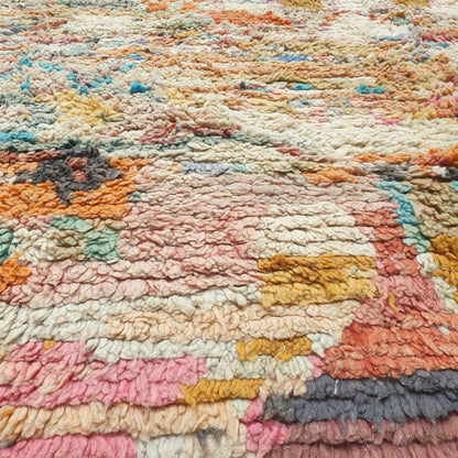 Detailed handwoven Berber symbols including diamonds, abstract shapes, stripes and central motifs in rich red, orange, pink, yellow and blue on authentic Boujad Moroccan rug