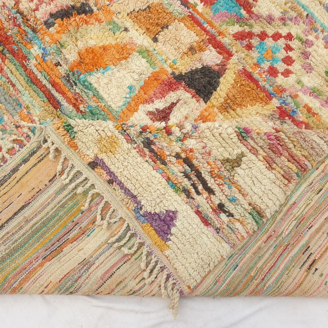 Hand-knotted fringe and detailed border in warm tones framing the bold geometric tribal design on 9x12 large Boujad Moroccan rug