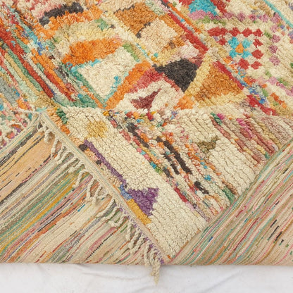 Hand-knotted fringe and detailed border in warm tones framing the bold geometric tribal design on 9x12 large Boujad Moroccan rug