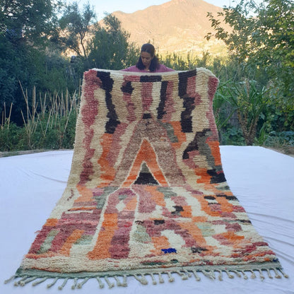 Handwoven 6x10 ft Boujad Moroccan rug with vibrant abstract design in orange, pink, black, cream and sage green on plush natural wool – ideal boho statement rug