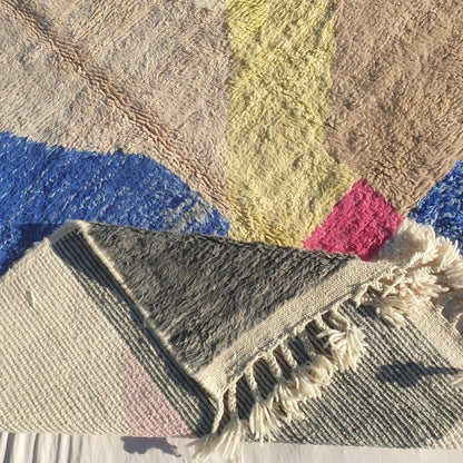 Hand-knotted fringe and detailed border in creamy ivory with pops of color on 6x9 multi-color abstract Beni Ourain Moroccan rug