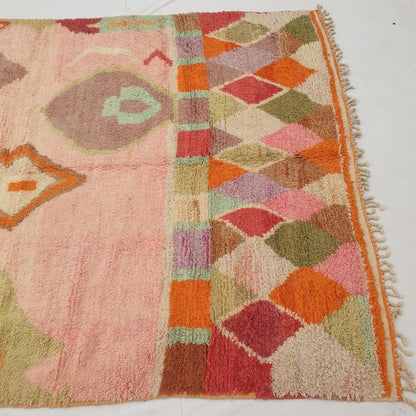Detail shot of the bright rainbow harlequin border on Hadita Moroccan rug - the cheerful, densely packed multicolour diamonds providing a joyful contrast to the softer rose pink field above