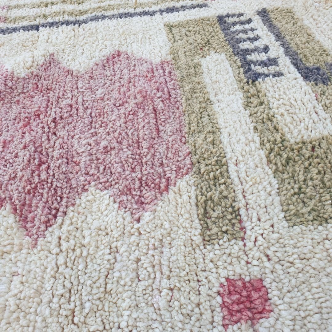 Close-up of Khazo Boujad Moroccan rug showing dense overlapping horizontal bars in olive, charcoal grey and terracotta red on an ivory wool ground — bold mid-century modern Berber graphic design.