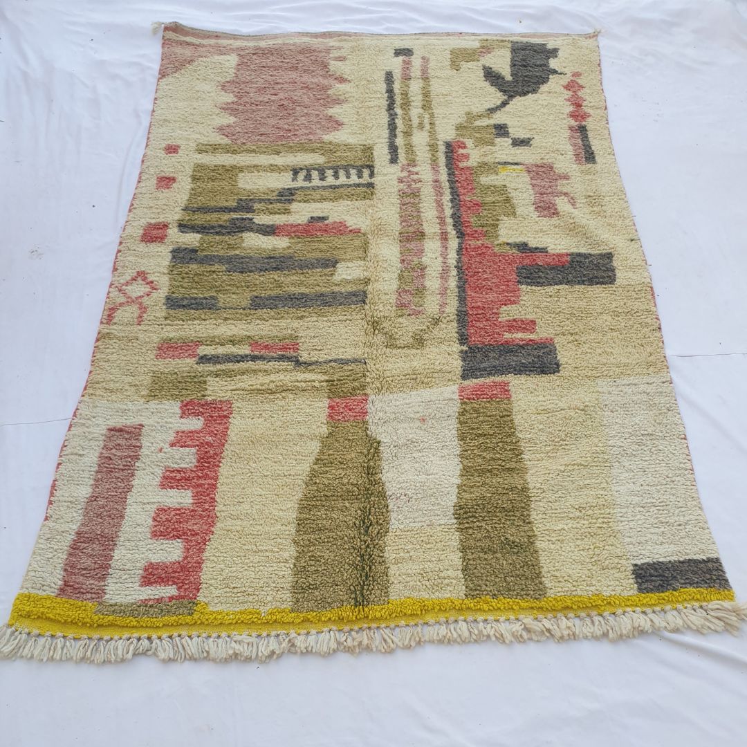 handwoven Boujad Berber rug (193x313 cm) laid flat, ivory ground with architectural olive and charcoal panels, coral accents, dark bird silhouette top-right, vivid yellow bottom border.