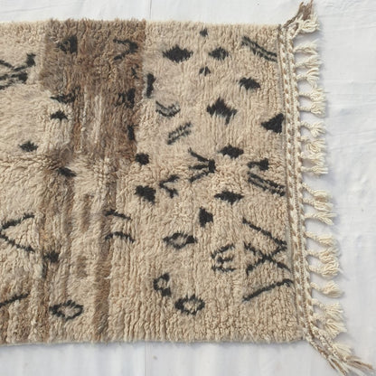 Striking black abstract symbols, crosses & motifs scattered on beige field of authentic Beni Ourain Moroccan wool rug