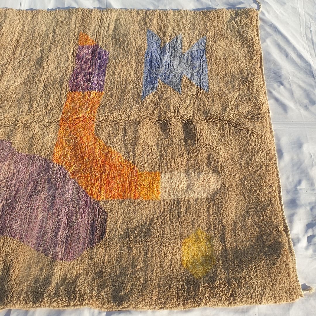Detail of orange and purple abstract shapes highlighting dense weave and fluffy texture of this high-end Moroccan rug