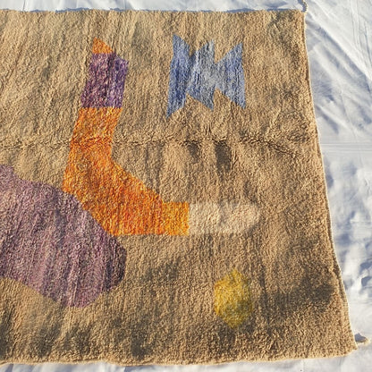 Detail of orange and purple abstract shapes highlighting dense weave and fluffy texture of this high-end Moroccan rug