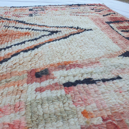 Detailed geometric motifs in pink orange on colorful Boujad Moroccan rug, natural wool texture