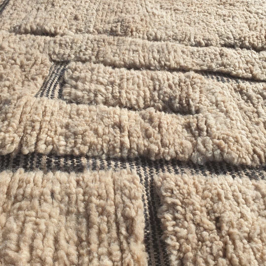 Detailed abstract black geometric blocks, lines and freeform tribal forms on authentic Beni Ourain wool rug, showcasing powerful Berber design contrast