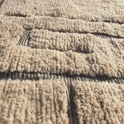 Detailed abstract black geometric blocks, lines and freeform tribal forms on authentic Beni Ourain wool rug, showcasing powerful Berber design contrast