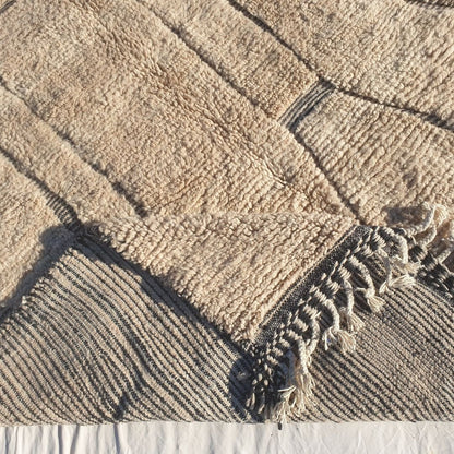 Hand-knotted fringe and detailed black border framing the large-scale abstract geometric pattern on 7x11 Beni Ourain Moroccan rug