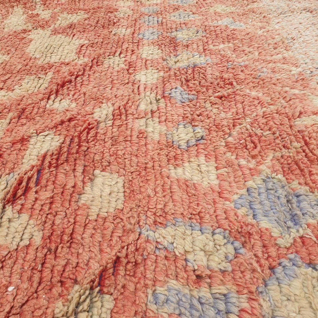 Detailed handwoven Berber abstract shapes including diamonds, freeform vertical bands, geometric symbols and organic motifs in pastel peach, coral, orange and yellow on authentic Boujad Moroccan rug