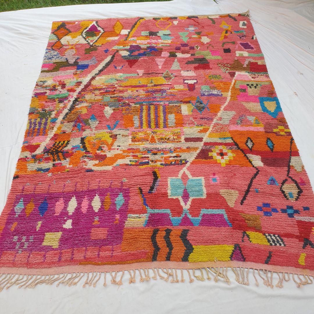 Authentic Boujad Moroccan rug 293×386 cm laid flat — warm coral salmon-pink background densely covered with all-over multicolor geometric motifs including diamonds, zigzags, stripes and triangles in orange, yellow, teal, purple, blue and green, handmade in Morocco by Berber women