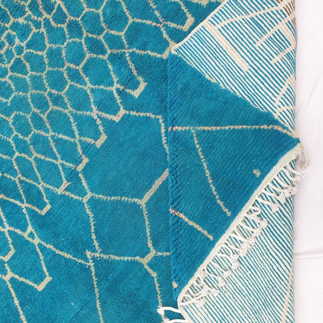 Hand-knotted fringe and detailed ivory border framing the vibrant teal honeycomb pattern on 10x10 square Beni Ourain Moroccan rug