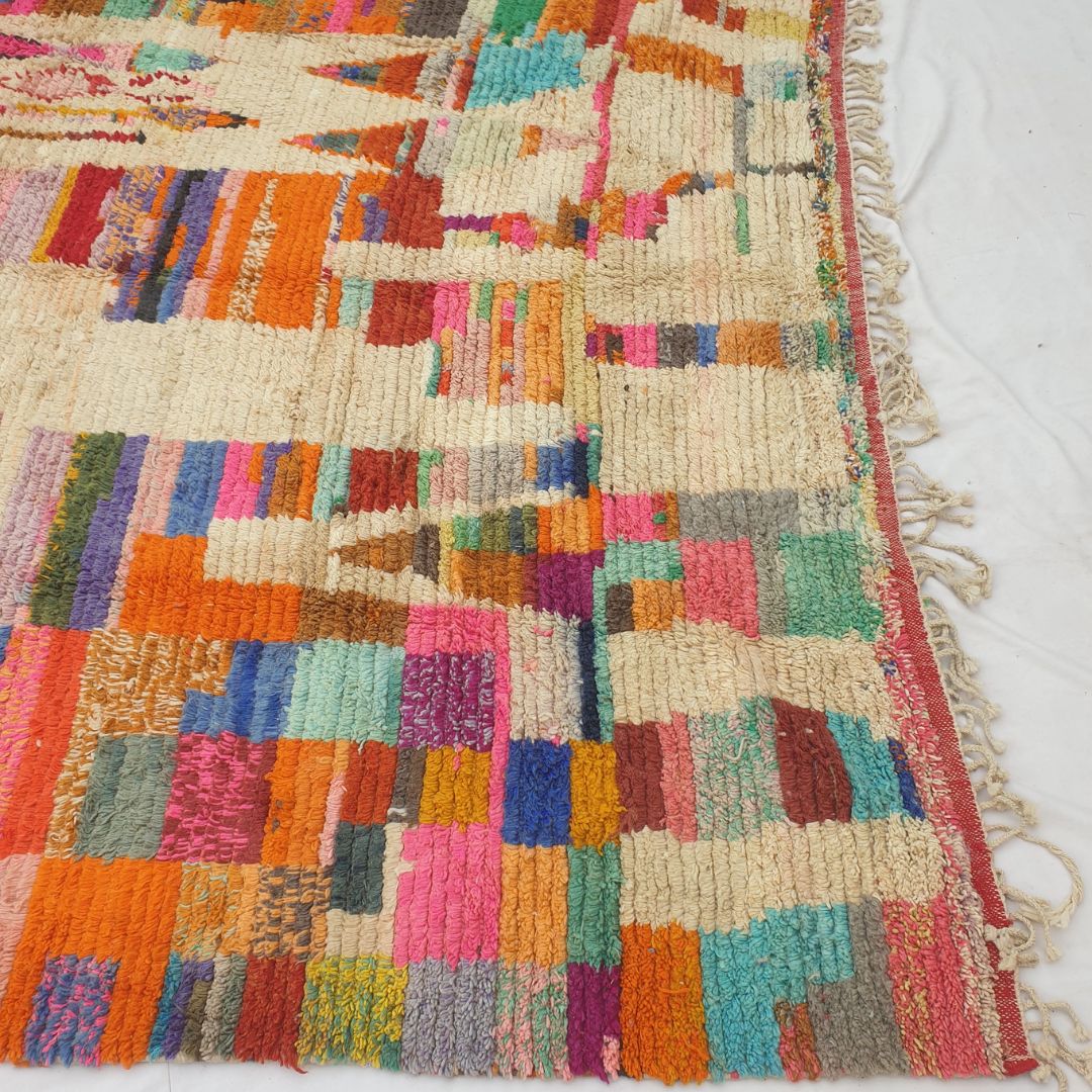 Bottom half of a large cream Moroccan wool rug featuring vertical ivory rivers alternating with dense multicolor stripe bands in orange, teal, red, pink, blue, yellow and green, with natural knotted fringe — showing the soft, thick texture and exceptional density of authentic Berber hand-knotted wool