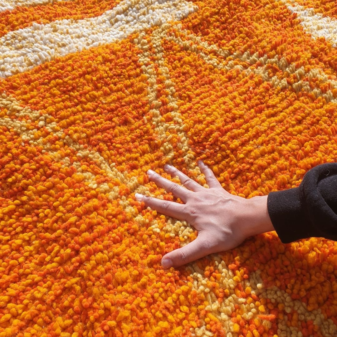Close-up of thick shag pile and natural wool texture on handmade Boujad orange and yellow rug
