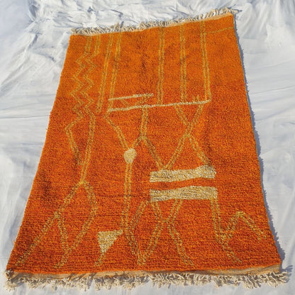 Full view of 6x10 Boujad rug with fringed edges and symmetrical abstract geometric design in orange and yellow tones