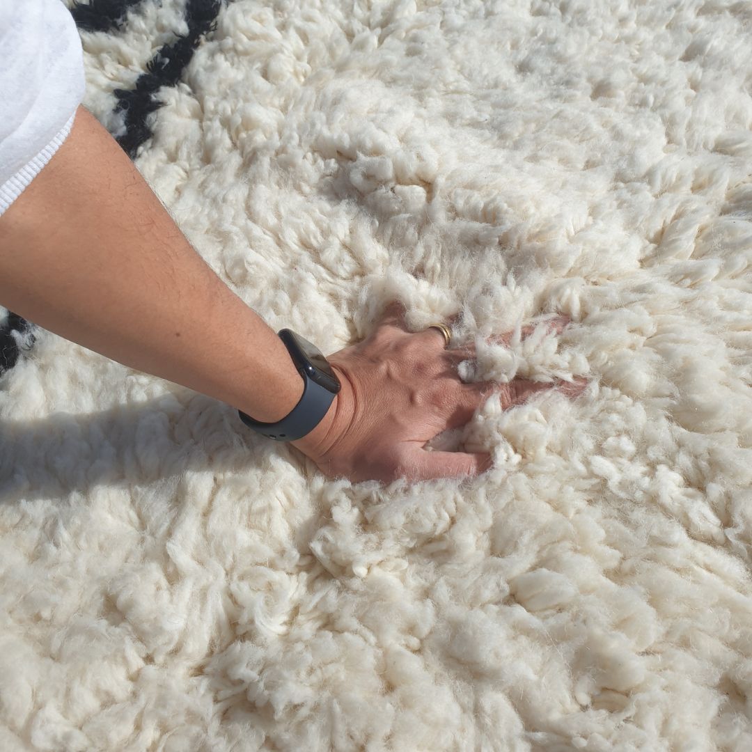 Ultra fluffy thick high-pile wool texture detail of pure white Beni Ourain plush shag rug