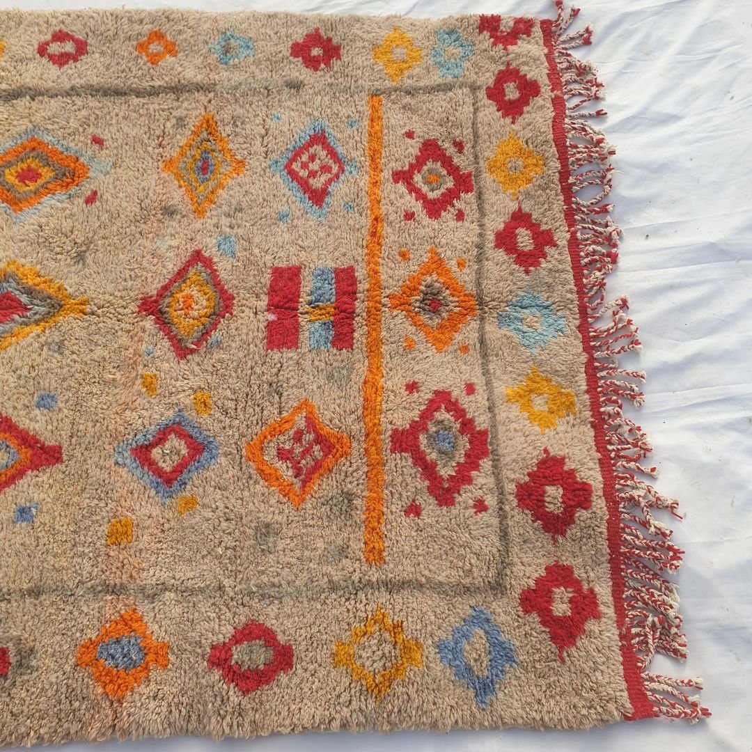 Bold tribal diamond patterns and geometric symbols in vibrant hues highlighting the dense weave and craftsmanship of the Moroccan wool rug