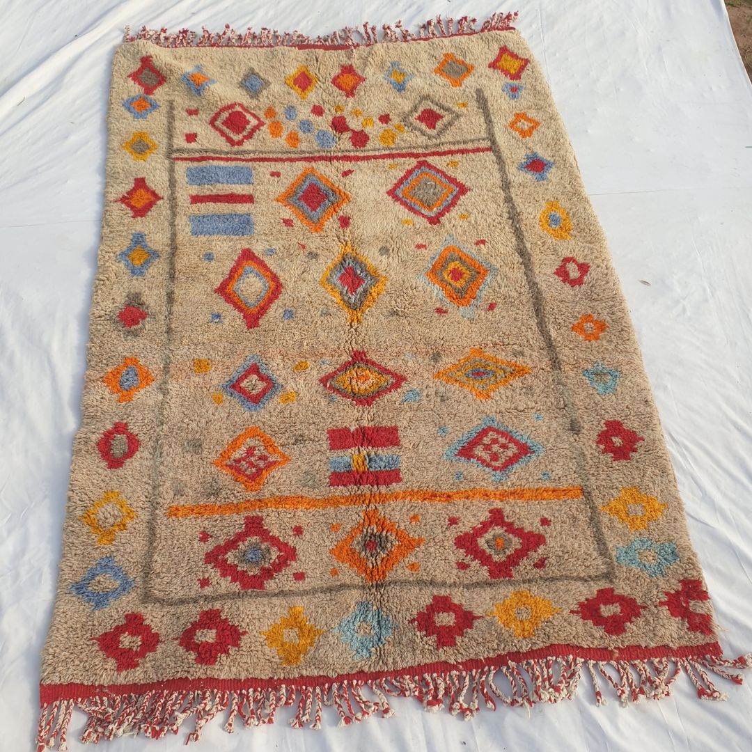 Full view of 6x9 Beni Mrirt rug with red fringed edges and all-over multicolored diamond geometric design showing traditional Berber artistry