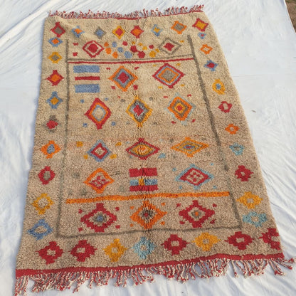 Full view of 6x9 Beni Mrirt rug with red fringed edges and all-over multicolored diamond geometric design showing traditional Berber artistry